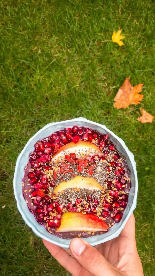 (Granat)apfel mit Chia- und Leinensamen auf einer Eiweiß-Acai-Mischung