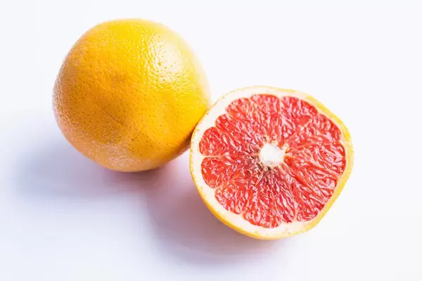 Grapefruit citrus fruit with half on white background
