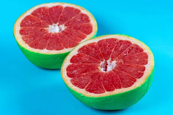 Grapefruit halves on pastel blue background. Summer concept