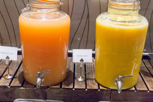 Grapefruitsaft und Orangensaft in großen Glasbehältern