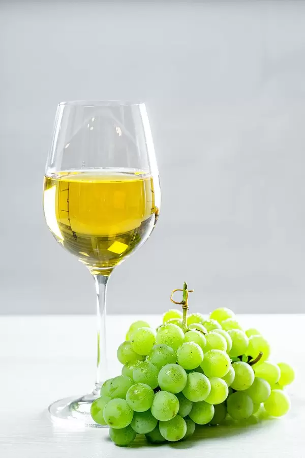 Grapes and white wine glass on a wooden table, front view (Flip 2019)