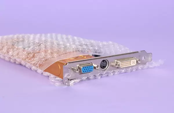 Graphic card packed in bubble wrap on purple background