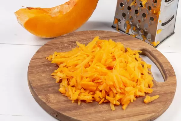 Grated Fresh Raw Pumpkin on the wooden board