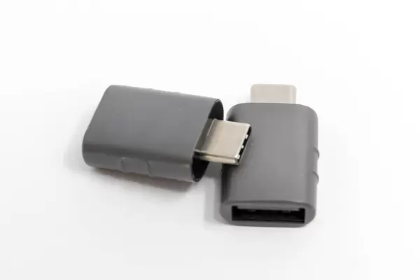 Grauer USB-Adapter von Syntech, für USB-C und USB-OTG auf einem weißen Tisch