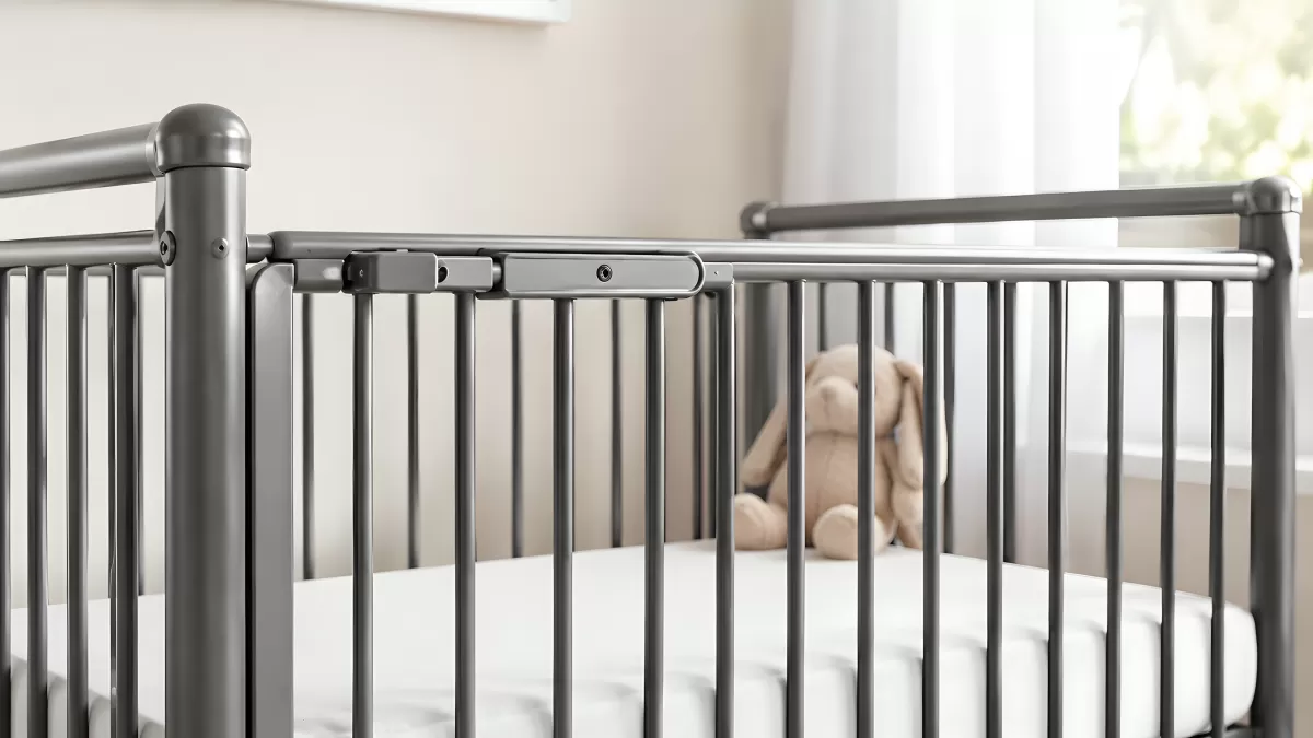 Graues Metallgitterbett mit Kamera und Plüschhase