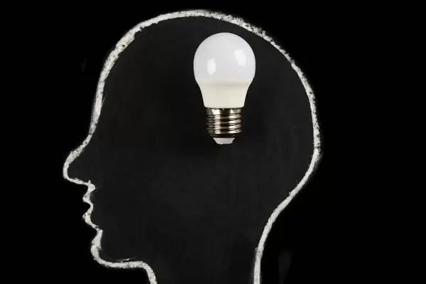 Great idea, finding solution concept, head silhouette with light bulb on dark background