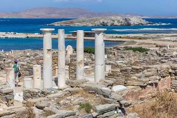 Greek columns of the House of Cleopatra in Delos. Uninhabited islands in the background