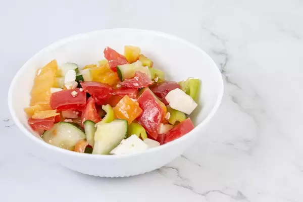Greek Salad in the bowl above grey marble table (Flip 2019) (Flip 2019)