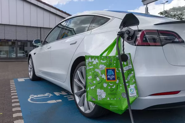 Green Aldi South shopping bag next to the Phoenix Conact Type 2 charging plug at the charging station for electric cars