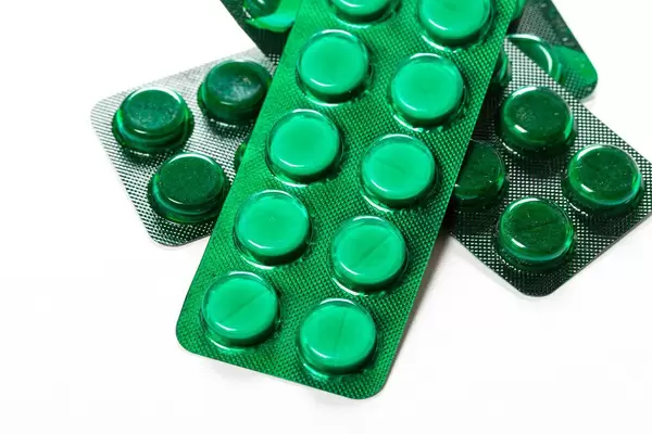 Green blisters with medical pills on a white background (Flip 2019)