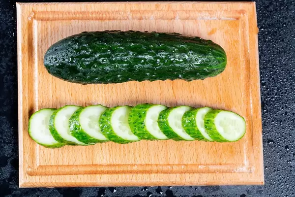 Green cucumber on kitchen Board