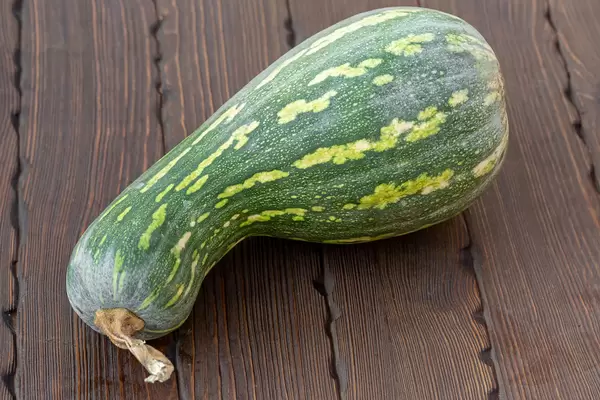 Green edible pumpkin on wooden background