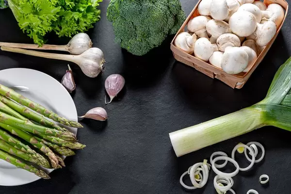 Green fresh vegetables and mushrooms on black background. The concept of cooking healthy food (Flip 2019)