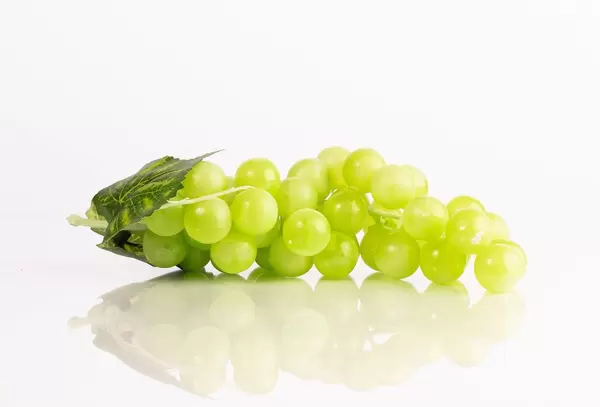 Green grape with leaves isolated on white background
