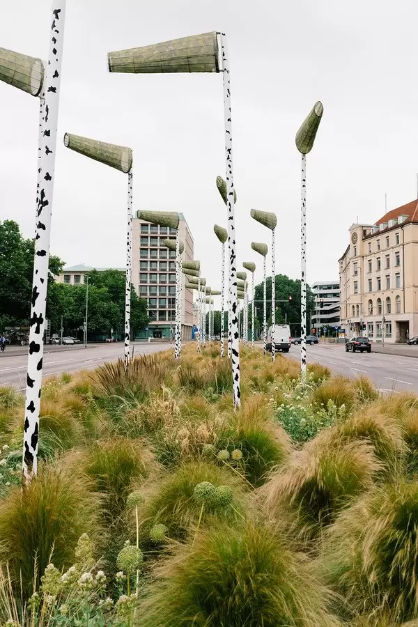 Green island of urban forrest with artificial birch pillars, green plants and wind vanes