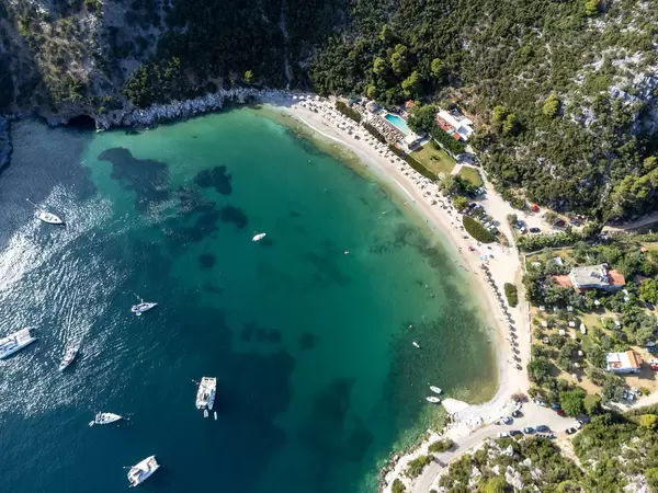 Green nature embraces the bay of Limnonari with sandy beach and shallow waters. Drone pic