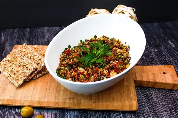 Green Olives Tapenade in a White Bowl with Crackers