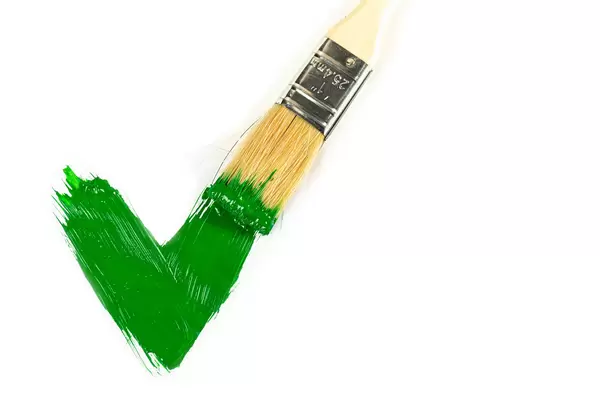 Green paint painted checkmark on white with a brush