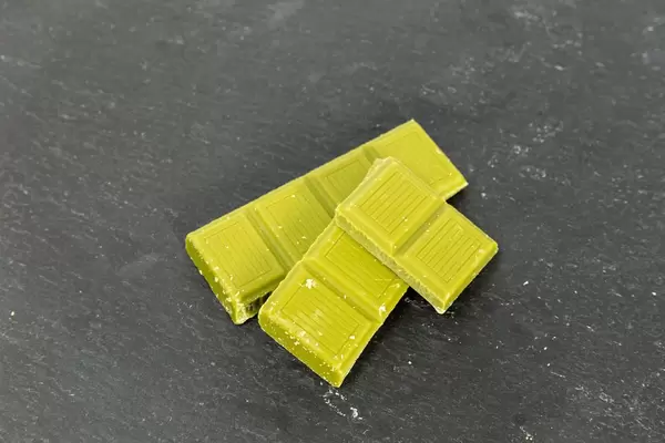Green vegan almond chocolate with matcha on black background