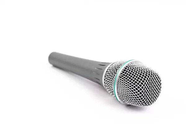 Grey Vocal Microphone above white background with copy space