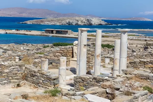 Griechische Säulen des Hauses der Kleopatra auf Delos. Unbewohnte Inseln im Hintergrund