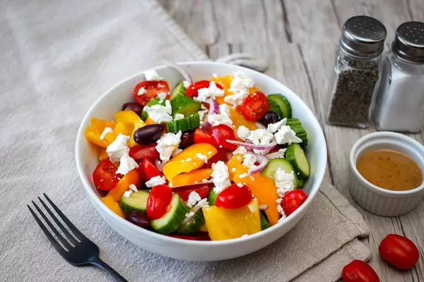 Griechischer Salat mit Cherrytomaten, Paprika, Gurke, Zwiebel, schwarzen Oliven und Fetakäse