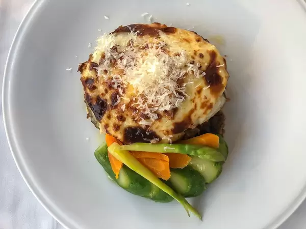 Griechisches Mittagessen Moussaka, gefüllte Auberginen mit Hackfleisch und gesunden Beilagen, in einem Restaurant der Hafenstadt Spetses
