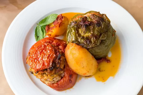 Griechisches Mittagessen "Gemista": bunte, gefüllte Paprika und Tomaten, Reis, Minze, Pinienkerne und Rosinen