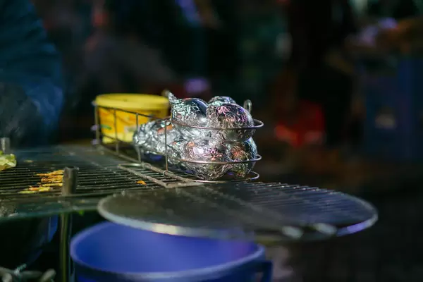 Grilled Eggs wrapped in Aluminium Foil on a Barbecue Grill