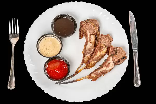Grilled lamb ribs with different sauces, top view