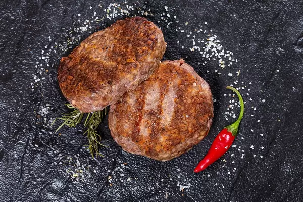 Grilled meat patties with salt and chili pepper. Top view (Flip 2019)