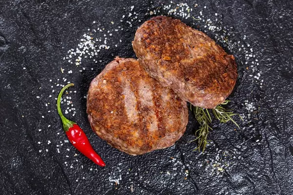 Grilled meat patties with salt and chili pepper. Top view