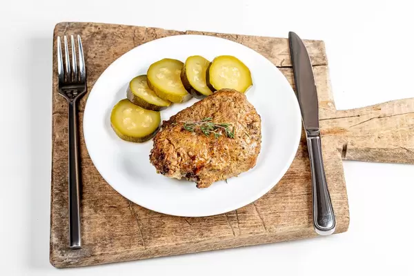 Grilled shashlik with pickled cucumber on the kitchen board