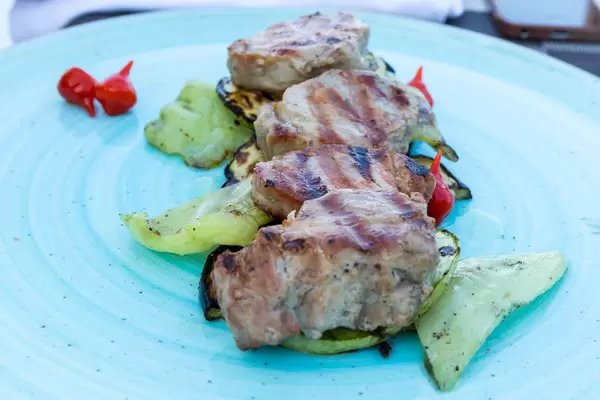 Grilled tenderloin with vegetables and anthotyro in a vinaigrette thyme sauce