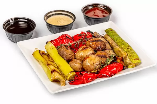 Grilled vegetables appetizer with sauces on white background