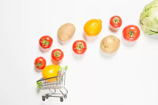 Grocery shopping products falling into a trolley