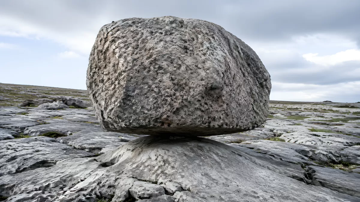 Großer Findling balanciert auf Kalksteinfelsen in Irland