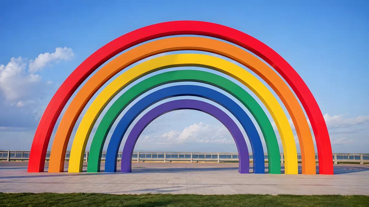 Großes Regenbogen-Kunstwerk am Hafen unter blauem Himmel