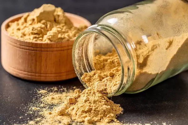 Ground mustard poured from a jar