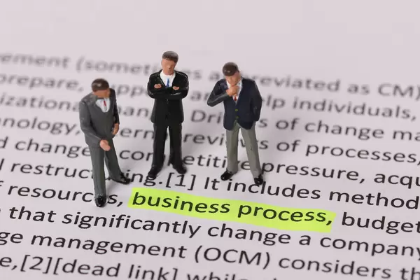 Group of businessman standing next to a text Business Process highlighted in yellow