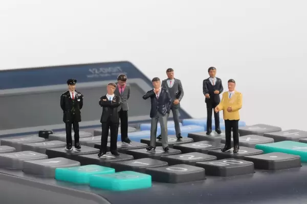 Group of businessman standing on calculator