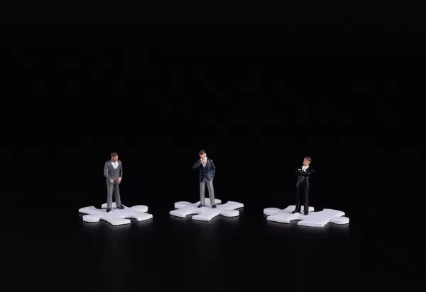Group of businessman standing on puzzle piece wtih black background