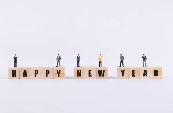 Group of businessman standing on wooden cubes with Happy New Year text