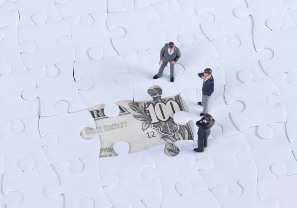 Group of businessman with missing jigsaw puzzle pieces over money dollar background