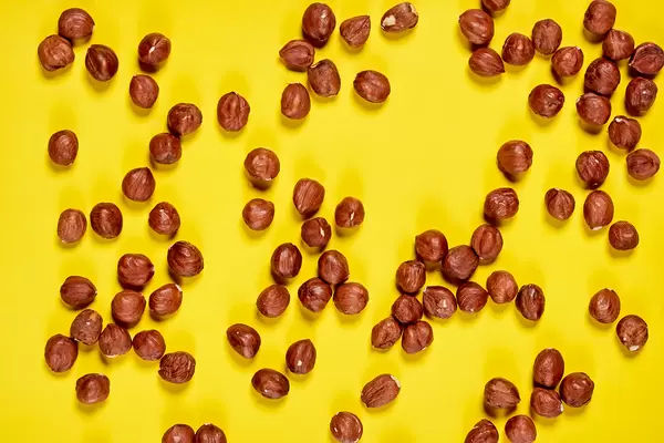Group of fresh hazelnuts on yellow background