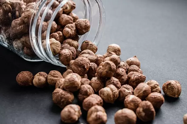 Group of hazelnuts in a glass jar, close up