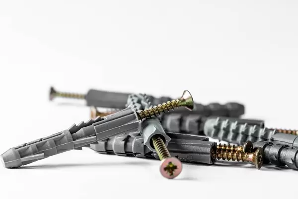 Group of iron screws and dowels to them on a white background