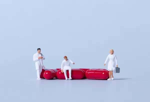 Group of medical workers with red pills