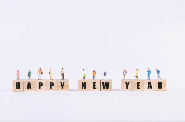 Group of people standing on wooden cubes with Happy New Year text