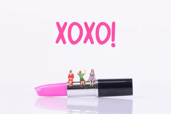 Group of womans sitting on make up with XOXO text